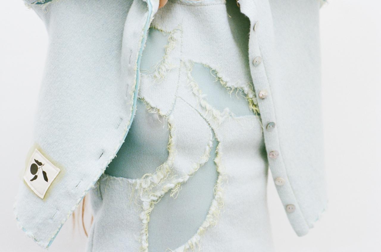 tenue-veste-bleu-clair-trou-forme-fleur-fil-debordant